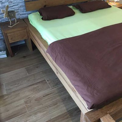 Holzbett mit Bezug und Nachttisch